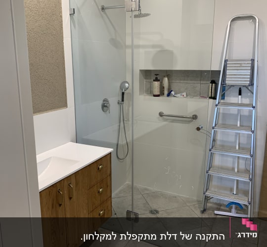 מקלחון זכוכית עם ראש מקלחת ומדף מוצרי טיפוח